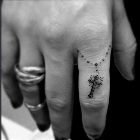 tattoo between thumb and index finger|cross tattoo on finger meaning.